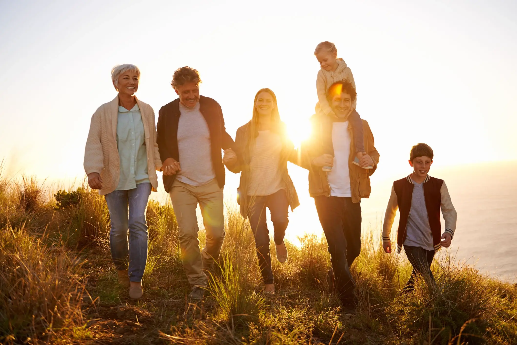 Multi-generational family walking together at sunset